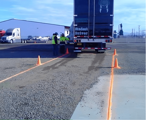 Truck backing up between orange cones